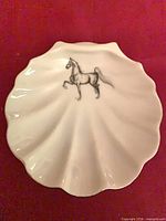Top view showing white scalloped dish and horse illustration