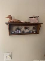 Full view of wall-mount shadowbox shelf with duck and well on top