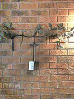 Wall hook rack and thermometer mounted on brick wall