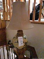 Full view of lamp showing ceramic body, wood base, shade