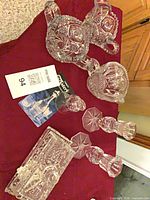 All items overview on red cloth: butter dish, candlesticks, sugar, creamer, bell