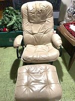 Front view of beige leather swivel chair and ottoman showing button-tufted cushions