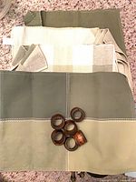 Stack of placemats with six wooden napkin rings on top