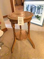 Full view of oak accent table showing legs and lower shelf