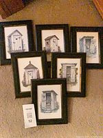 All six framed outhouse prints arranged on carpet