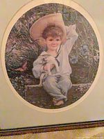 Close-up of “Le Beau” print showing boy with puppy, oval mat and frame