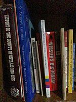 Shelf with multiple book spines including History of the County of Ontario, St. Andrew’s Chalmers, Webster’s Dictionary