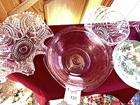 Overview of four bowls on table: ruffled clear glass, pink Depression glass, cut crystal style, green Wedgwood ceramic