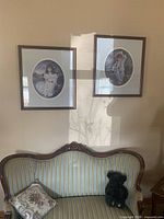 Front view of loveseat under framed pictures