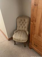 Front view of upholstered Victorian chair in corner