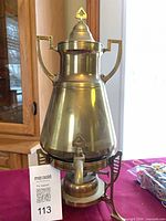 Full view of brass samovar on stand with burner visible