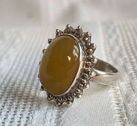 oblique view of ring showing cabochon carnelian and bead halo