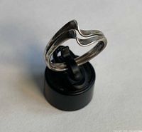 Ring on stand showing wave design and band