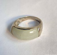 Sterling silver ring with pale green jade stone on white background