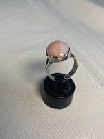Front angle of sterling silver ring with pink opal cabochon