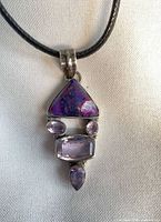 Front view of pendant on cord showing stones and settings