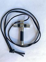 Front view of sterling silver and leather cross pendant with cord