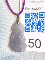 Pendant on display card showing colour and carving detail