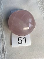 Top view of rose quartz palm stone on numbered tag