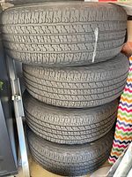 Stack of four tires showing tread and sidewalls
