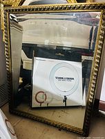 Front view of rectangular antique mirror with ornate gold-tone frame