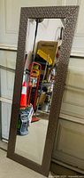 Tall rectangular mirror leaning against garage door