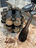 Spice rack, large fork and spoon displayed on countertop