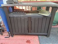 Front view of resin cabinet with stainless top and accessories resting on surface