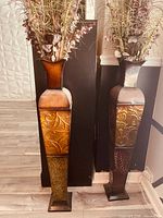 Both tall metal vases side by side showing overall shape and design; left one represents lot item