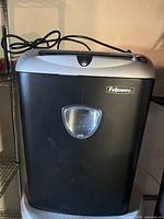 Front view of Fellowes shredder showing logo, bin window and attached power cord