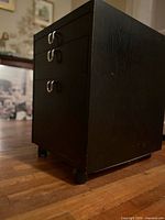 Perspective view of black three-drawer cabinet on casters