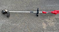 Full view of Toro cordless string trimmer lying on ground