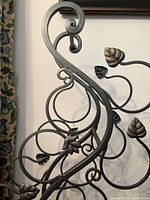 Close-up of scroll and leaf detailing on wrought iron wine rack