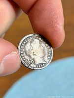 Obverse of 1896 Barber dime held between fingers