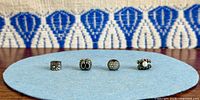 Front view of all four Pandora charms aligned on blue felt
