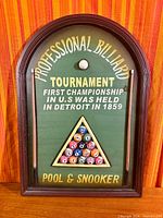 Full view of arched billiard tournament sign on wood surface