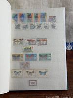 Album page with multiple butterfly stamps from various countries