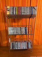 Full view of three-tier metal wire shelf loaded with CDs
