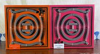 Front view of both Hermès gift set boxes, orange and fuchsia