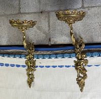 Front view of both gilt brass wall brackets mounted side by side