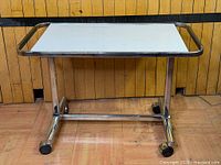 Full view of rolling side table showing top, frame and casters
