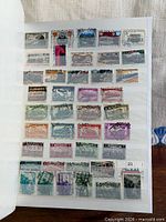 Open album page displaying multiple train-themed stamps in mounts