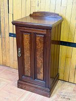 Front angled view showing walnut cabinet, burr panels, brass handle