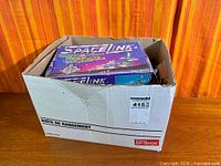 Cardboard storage box containing Space Link retail box