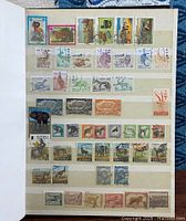 Album page with multiple Angola and other animal stamps