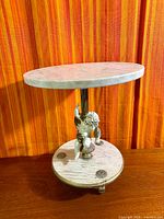 Full view of pedestal showing marble top, cherub figure, base