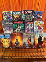 All twelve graphic novels on wire stand, front covers visible