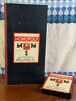 Long black Monopoly box and small component box standing upright