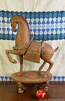Left-side view of redware horse on pedestal, shows raised leg and saddle detailing