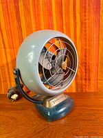 Front angled view of vintage Vornado table fan showing grille, blades and base